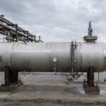 Large horizontal acid gas knock-out drum installed in a refinery flare system, with piping connections and safety instrumentation visible