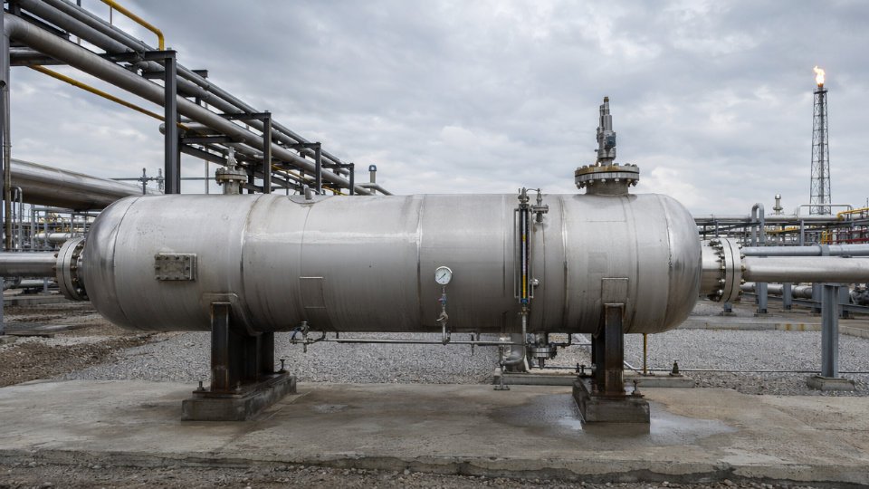 Large horizontal acid gas knock-out drum installed in a refinery flare system, with piping connections and safety instrumentation visible